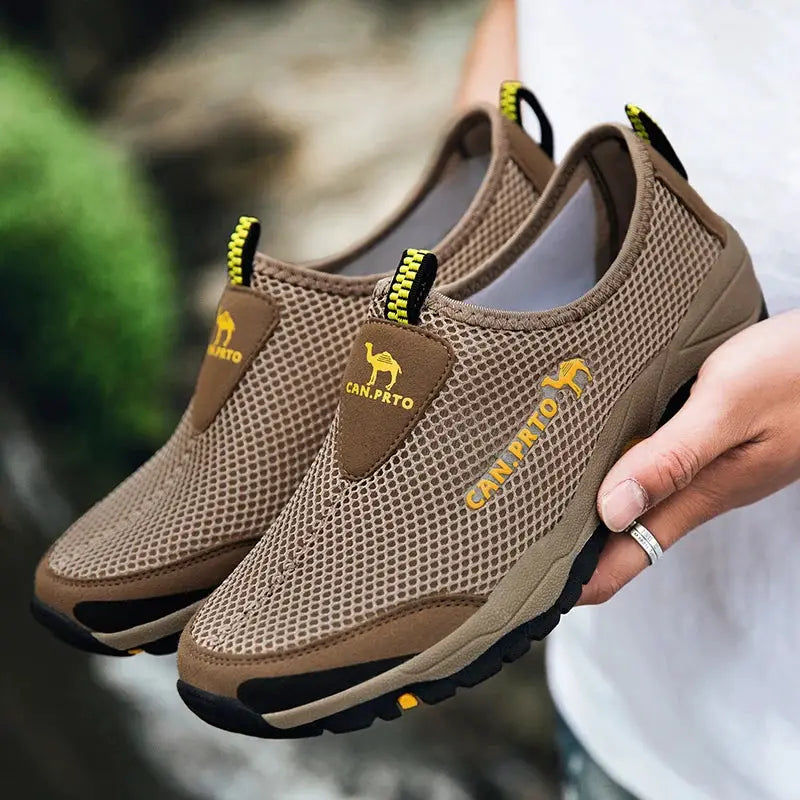 Pair of men's tan-brown mesh slip-on sneakers with yellow logo patch