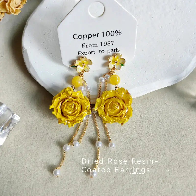 Pair of long yellow epoxy resin rose earrings with pearl-detailed chains