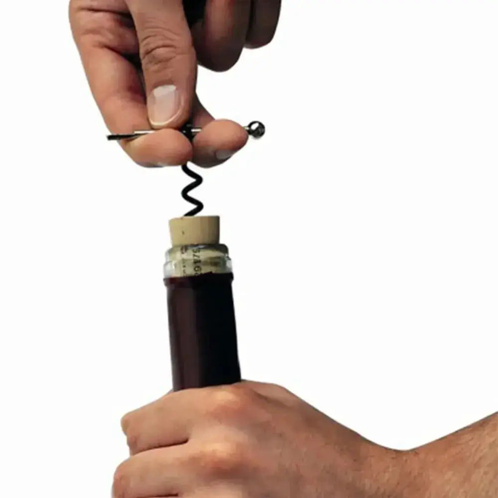 Bottle opener corkscrew mini EDC keyring tool with black spiral, pulling cork from dark wine bottle