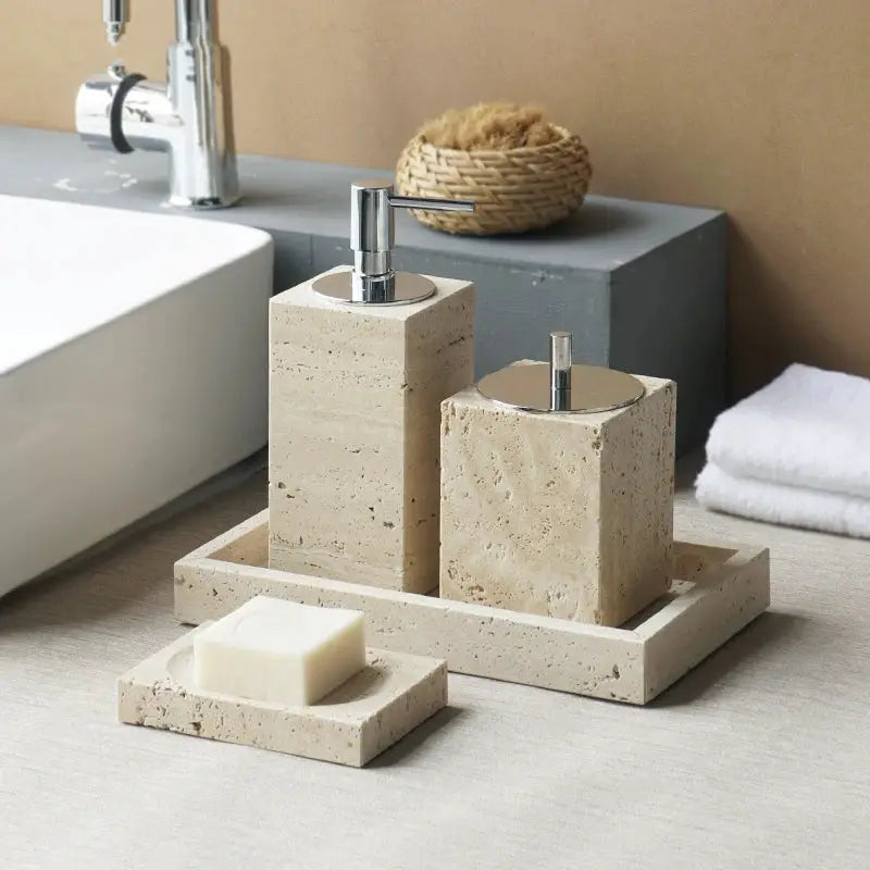 Beige travertine bathroom accessories set with soap dispenser, soap dish, reed diffuser and vanity tray