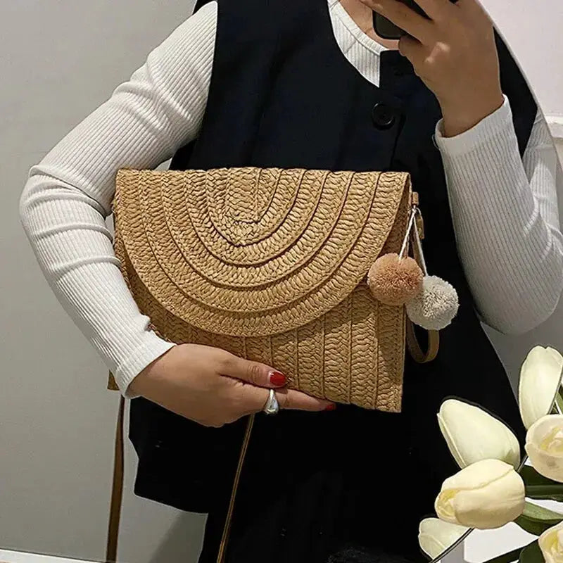 Simples Market handmade straw crossbody bag, natural beige envelope style with pom-pom charm