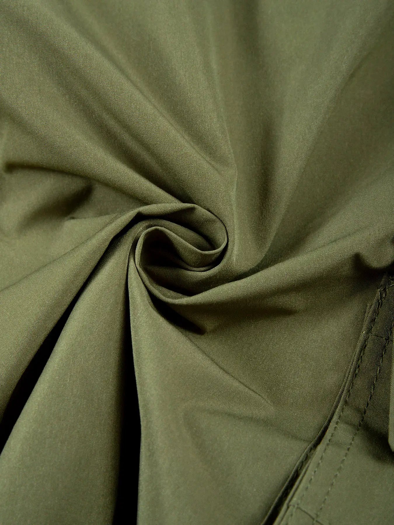 Cargo shorts fabric close-up in olive green with visible stitching