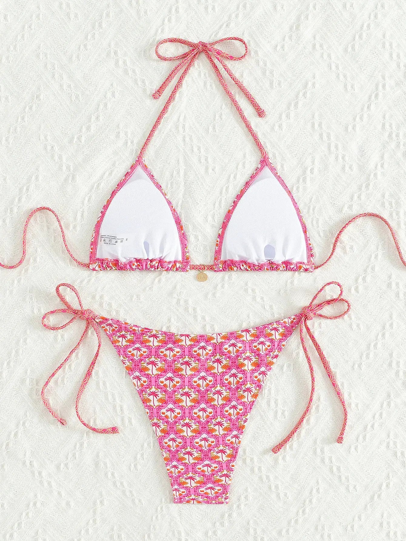 Triangle bikini set with pink floral print and white cups; halter top and Brazilian bottoms.