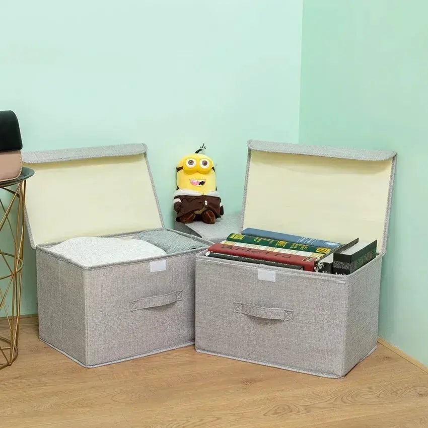 Two gray washable cotton-linen foldable storage boxes with lids, one filled with books.