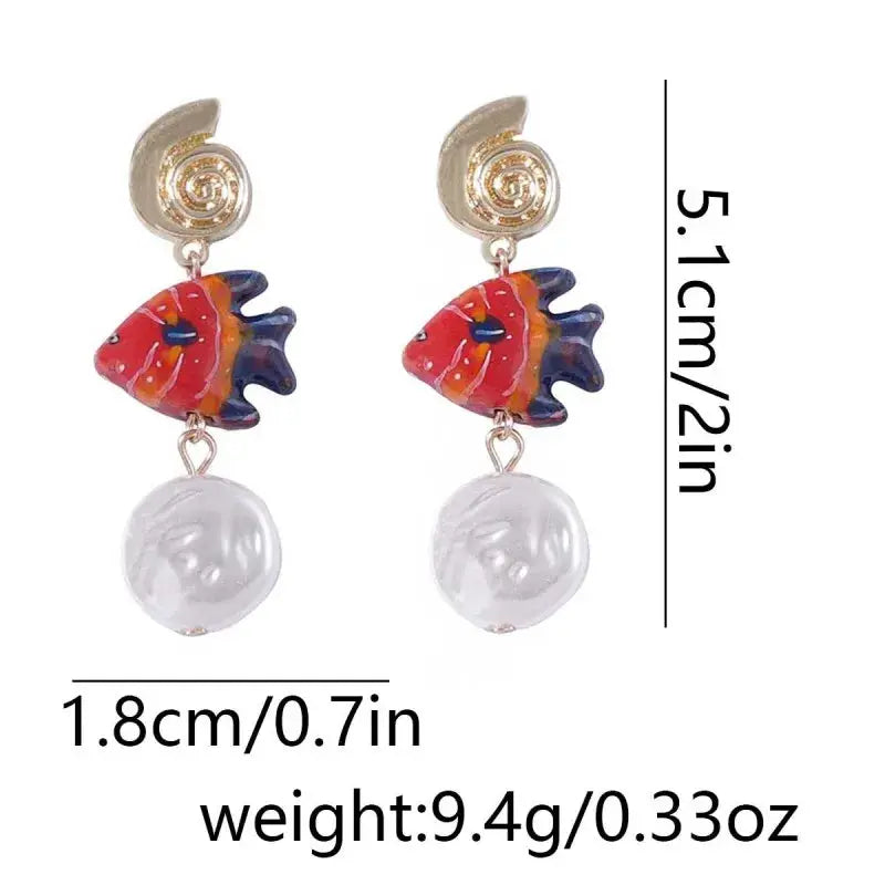 Octopus earrings, red-orange glass octopus with white pearl drop, gold spiral studs; pair by Simples Market
