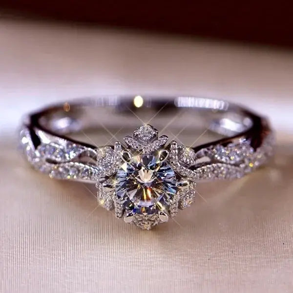Silver engagement ring with round white zircon center stone and pave halo on a floral band
