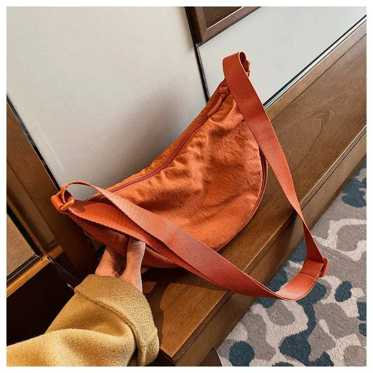 Casual orange nylon hobo crossbody bag for women with an adjustable shoulder strap