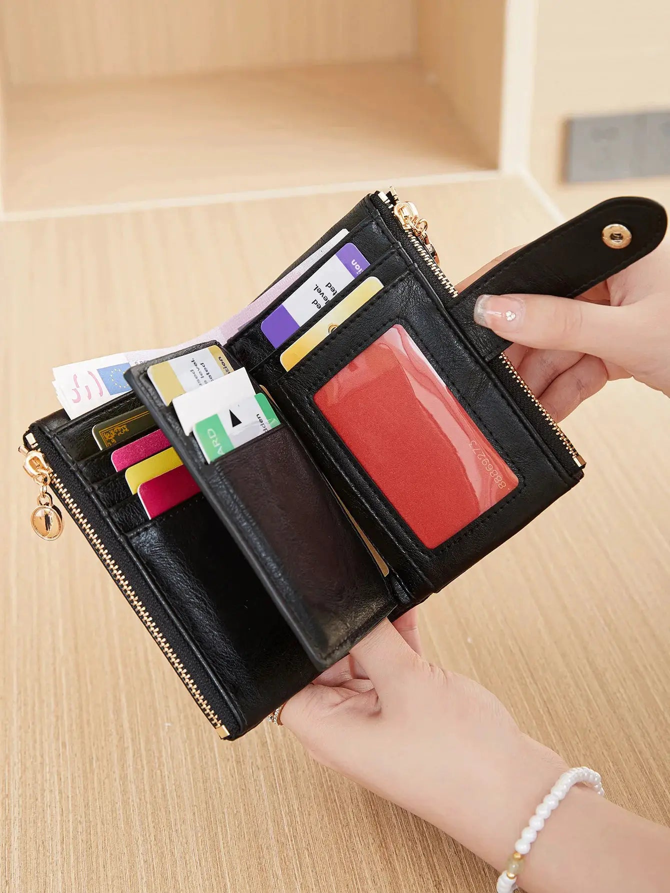 Black leather minimalist wallet with multiple card slots and double-zipper compartments.