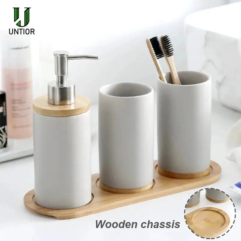 UNTIOR ceramic bathroom accessories set with soap dispenser, toothbrush holder, and tumbler on a wooden chassis