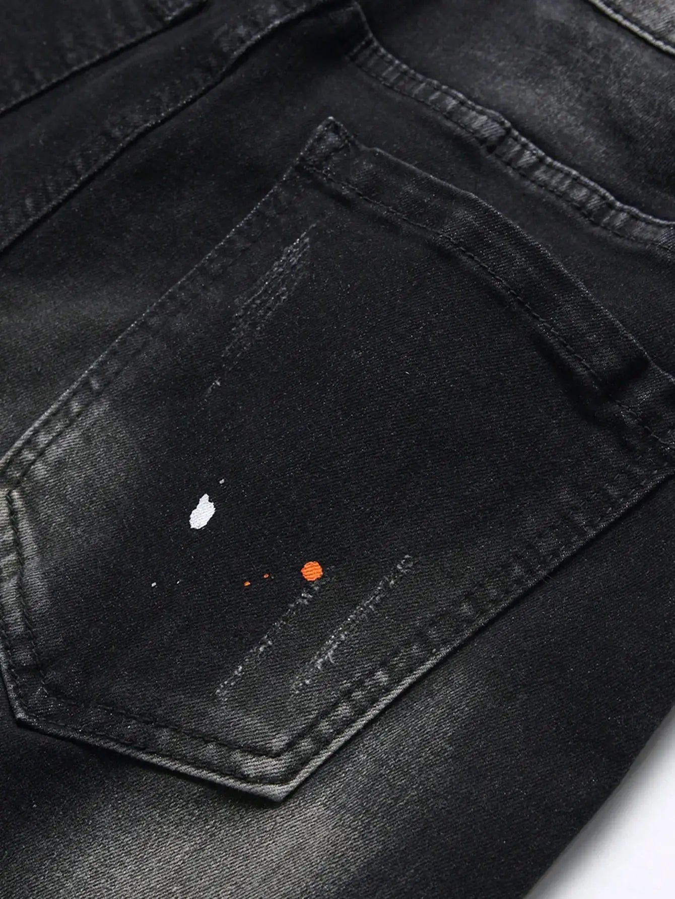 Simples Market men's denim shorts, black stretch denim with distressed detail and paint splatters, knee-length