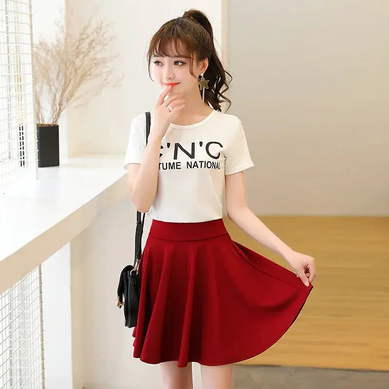 Flared red mini skirt with pleats; casual chic style worn with a white T-shirt