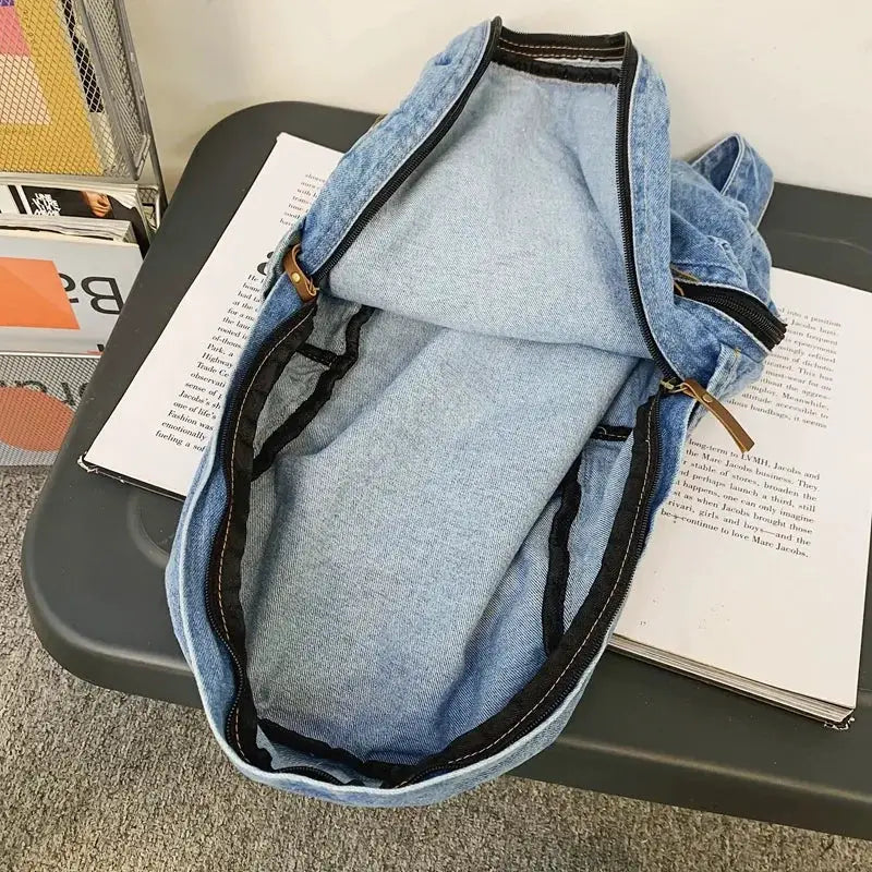 Denim school backpack in light blue with multiple pockets and zippers