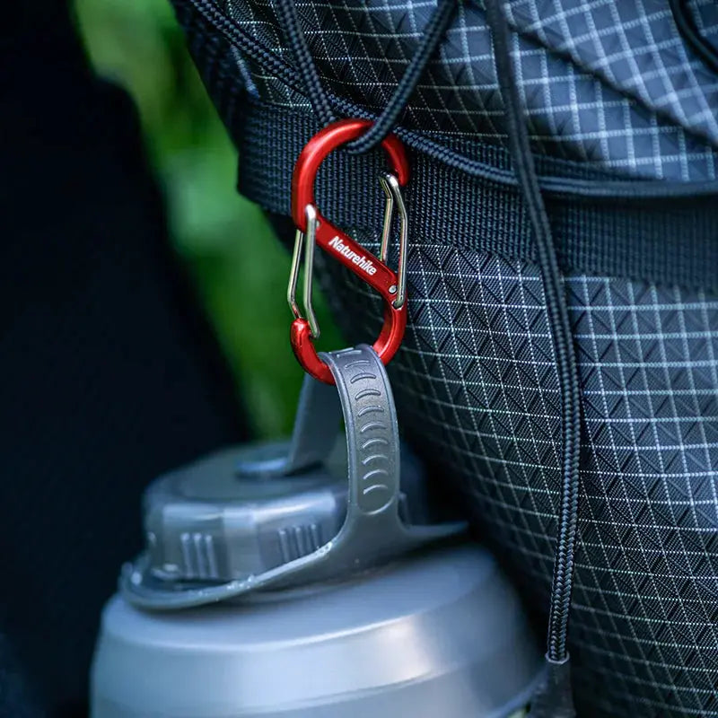 Naturehike aluminum S-shaped mountaineering buckle keychain attached to a backpack with a water bottle
