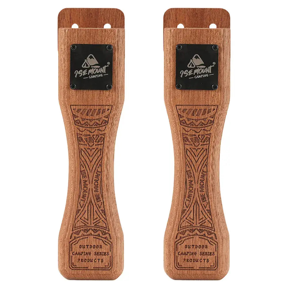 Two solid wood grill pan handles with carved tribal patterns and metal mounting plates for camping.