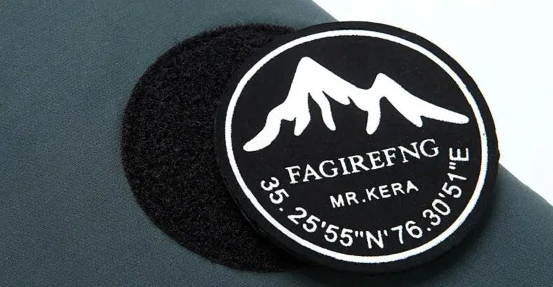 Winter down jacket by Simples Market with a round logo patch featuring mountains on black fabric