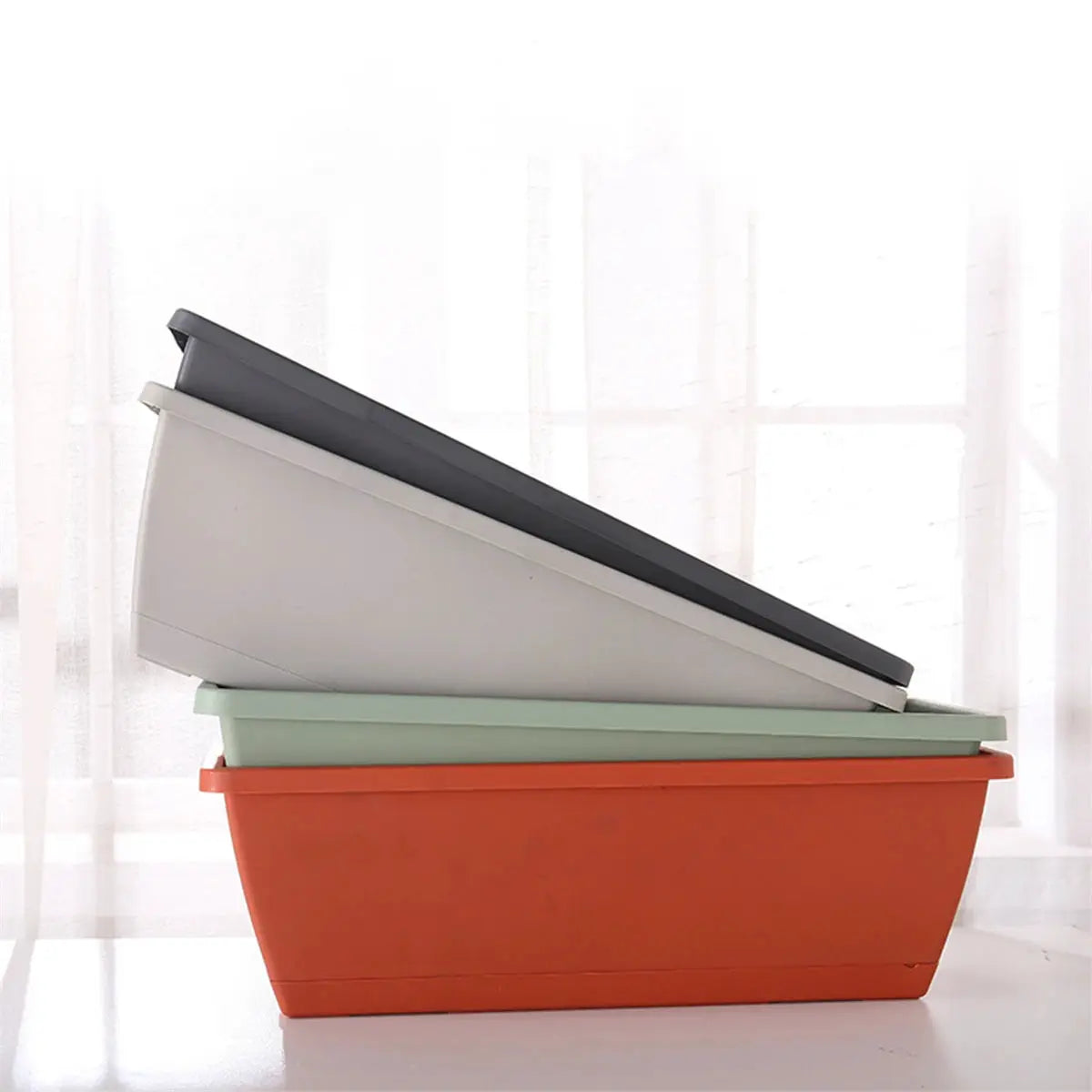 4-piece rectangular plastic balcony planter set with trays in orange, mint green, light gray, and dark gray.