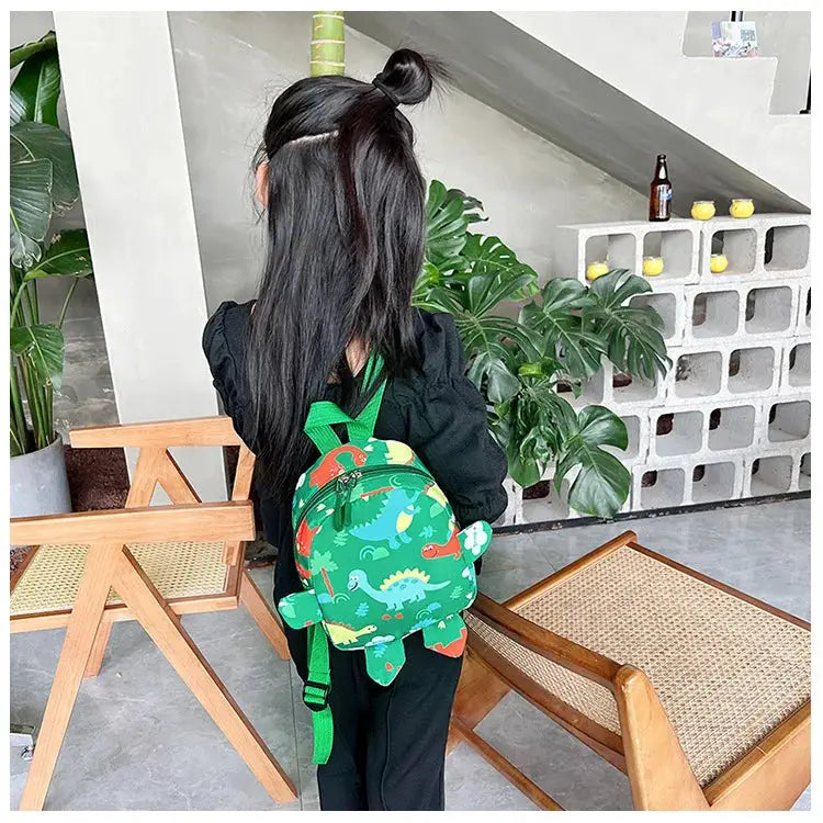 Kids dinosaur backpack, green with cartoon dinosaurs, worn by a child