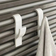 Simples Market white metal towel rail hooks clipped to a radiator with towel hanging