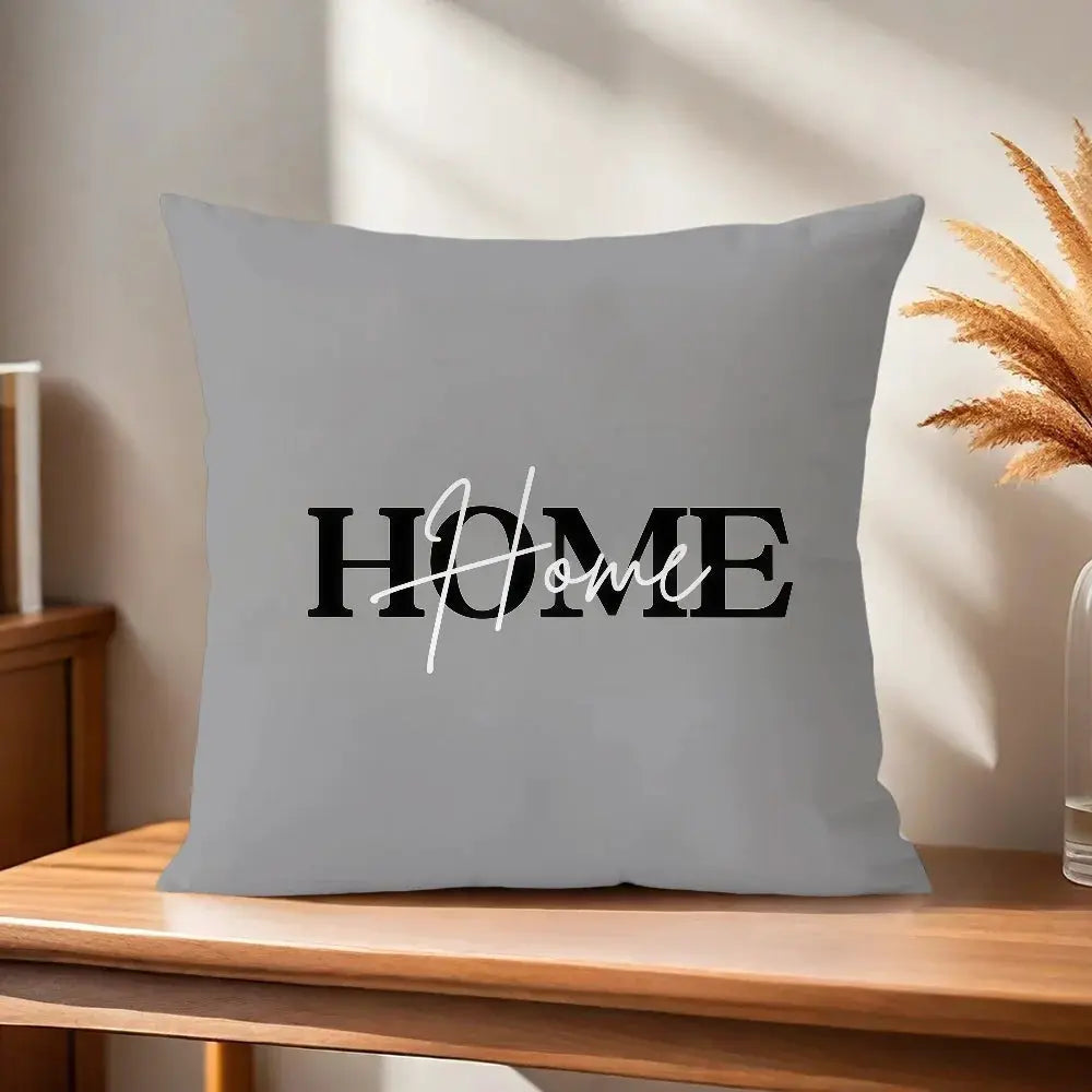 Gray pillow cover with black HOME typography and white cursive Love overlay.