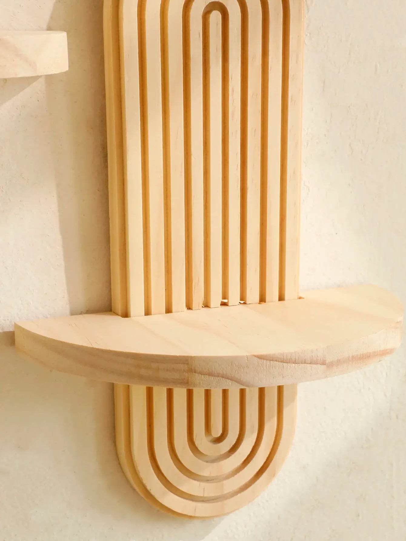 Boho-style wooden wall shelf, natural finish, wall-mounted with curved geometric back panel.