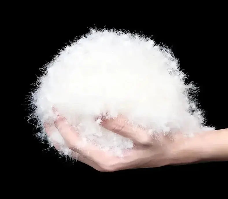 White duck-down insulation fluff held in hand, material sample for winter puffer jackets