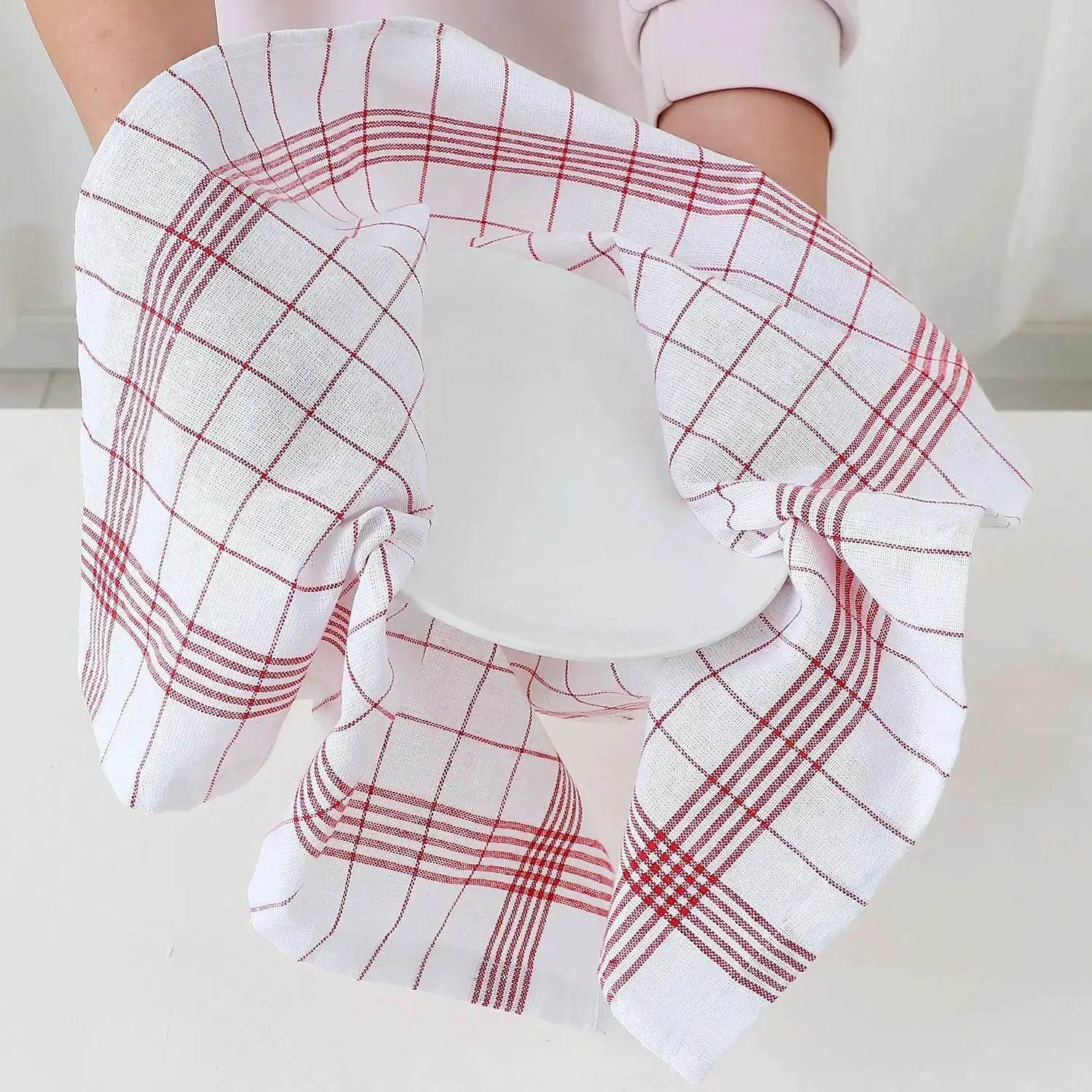 Large white kitchen towel with red plaid pattern, Simples Market, shown wrapped around a plate.