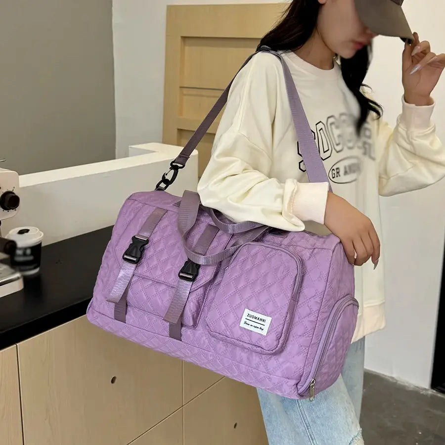 Travel duffle bag in lavender purple, quilted nylon with front zip pocket, dual buckle straps, ZUOMANI badge