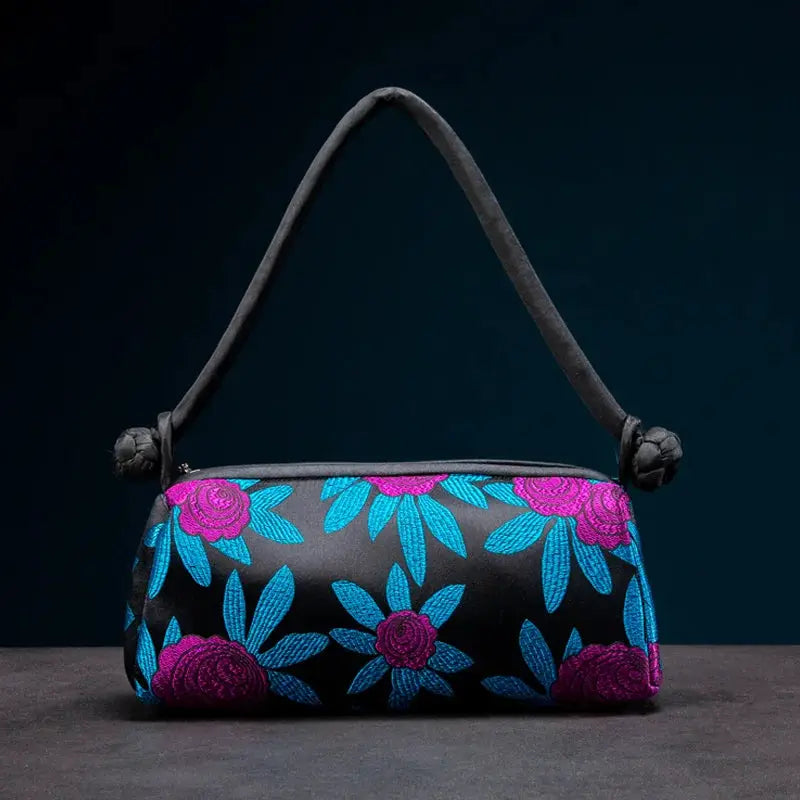 Small fashion shoulder bag with blue and magenta embroidered flowers on black satin