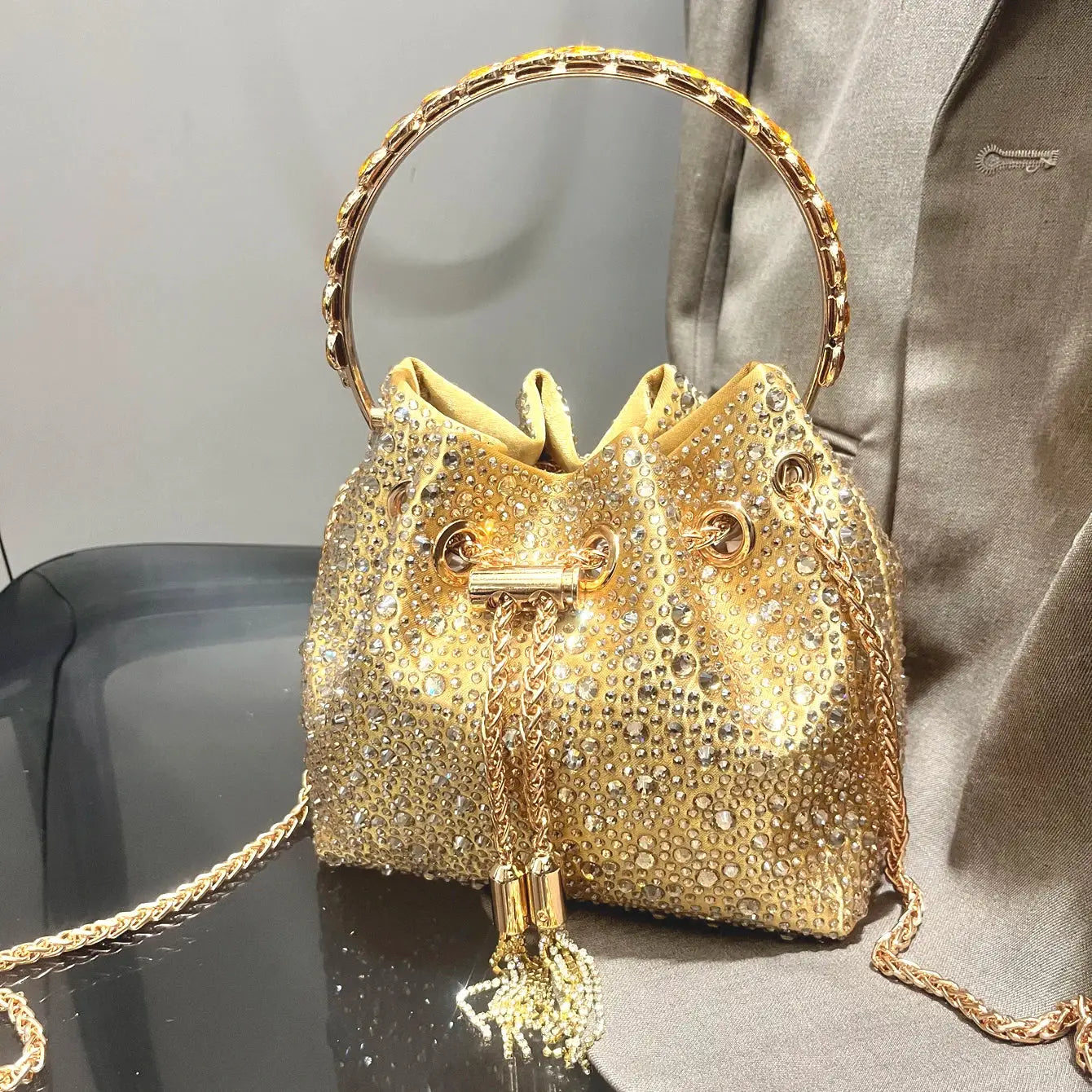 Gold rhinestone evening clutch bag with round jeweled handle and gold chain