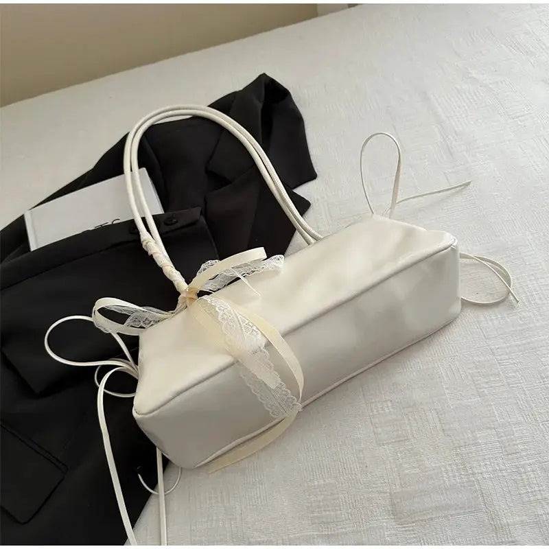 White PU square shoulder bag by Simples Market with lace bow and long strap