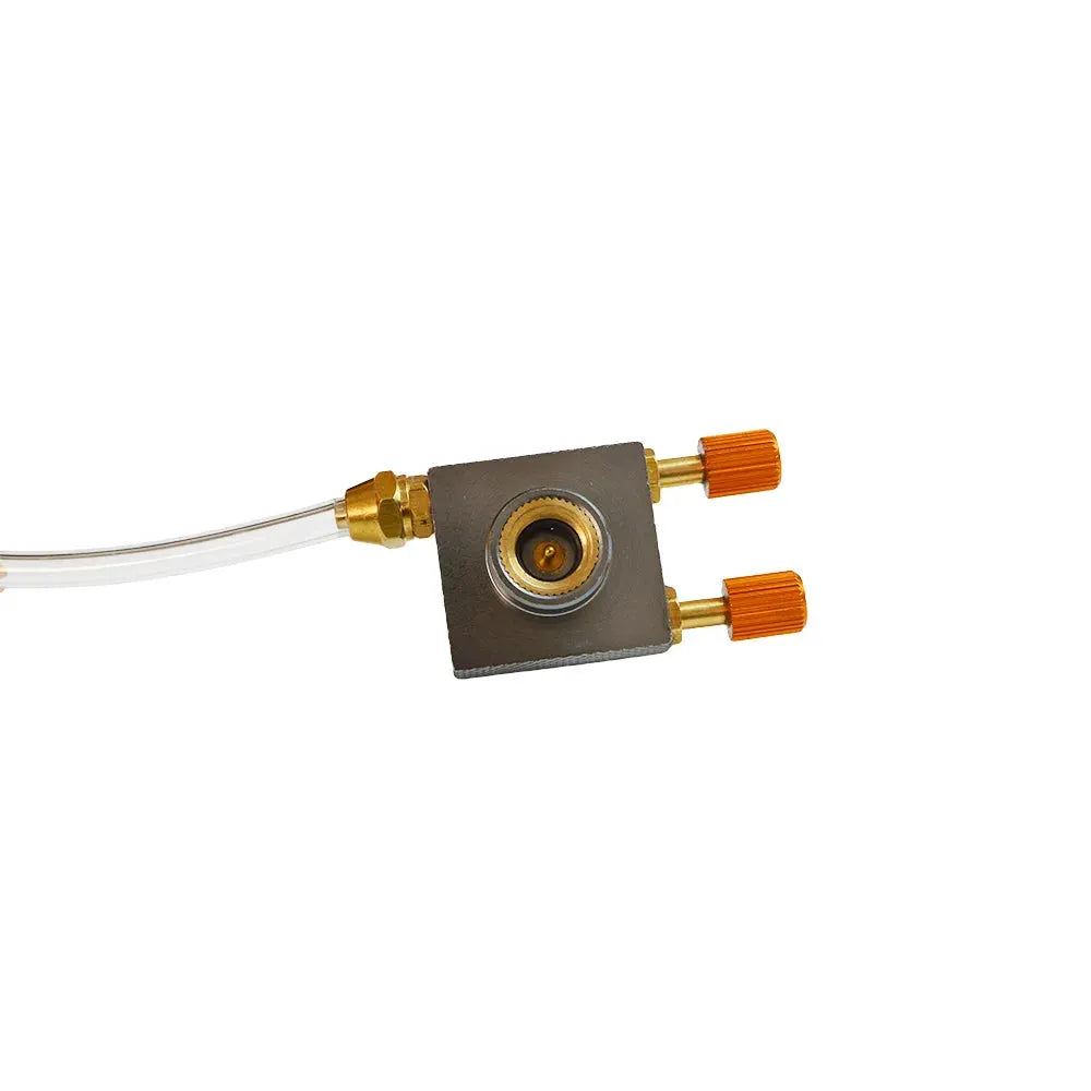 Camping gas refill adapter with brass fittings and orange knobs on a square metal block, connected to a clear hose