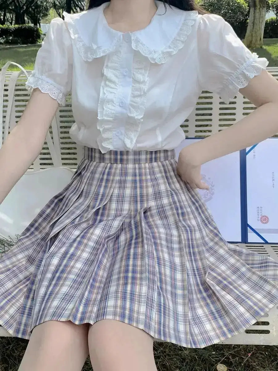 White lolita blouse with lace Peter Pan collar and puff sleeves, paired with a lavender plaid pleated skirt.