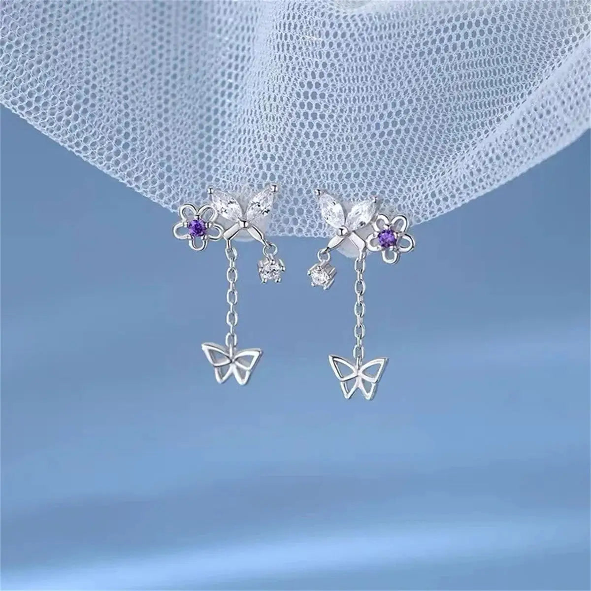 Pair of Simples Market butterfly tassel drop earrings, silver-tone with purple crystals and clear stones