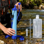 Portable emergency survival water filter straw by Simples Market in blue with strap, shown with a clear hydration bottle.