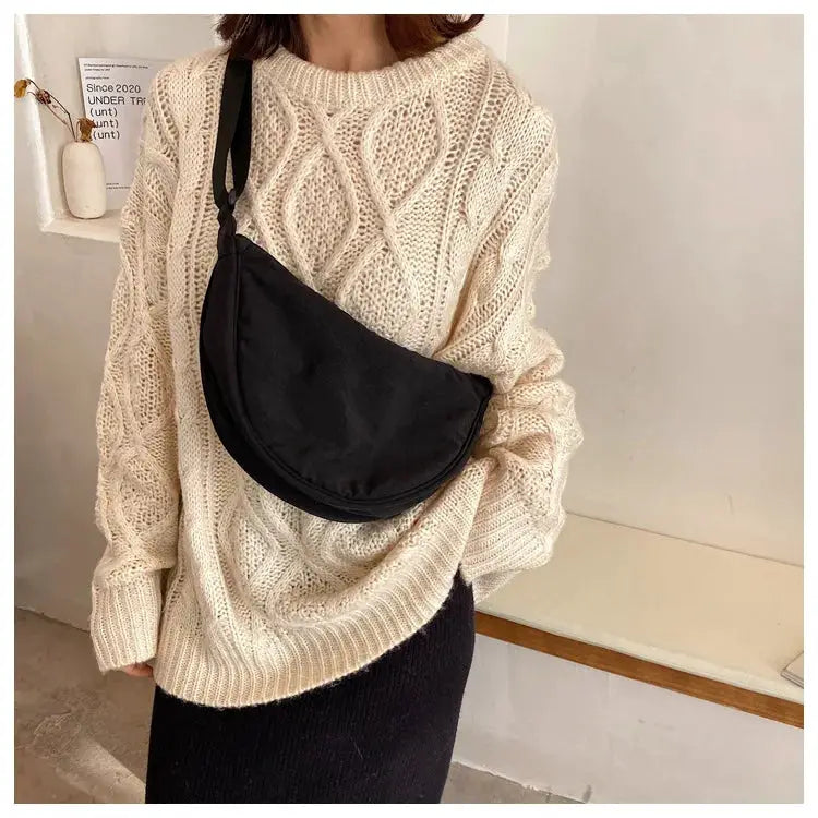Simples Market casual nylon hobo crossbody bag in black worn over a chunky beige knit sweater