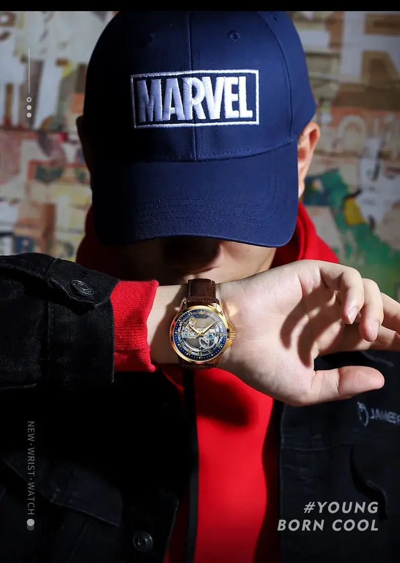 OLEVS 6661 automatic men's wristwatch with gold-tone case, blue skeleton dial, brown leather strap.