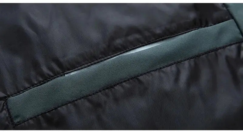 Men's down jacket close-up: black fabric with dark green trim panel