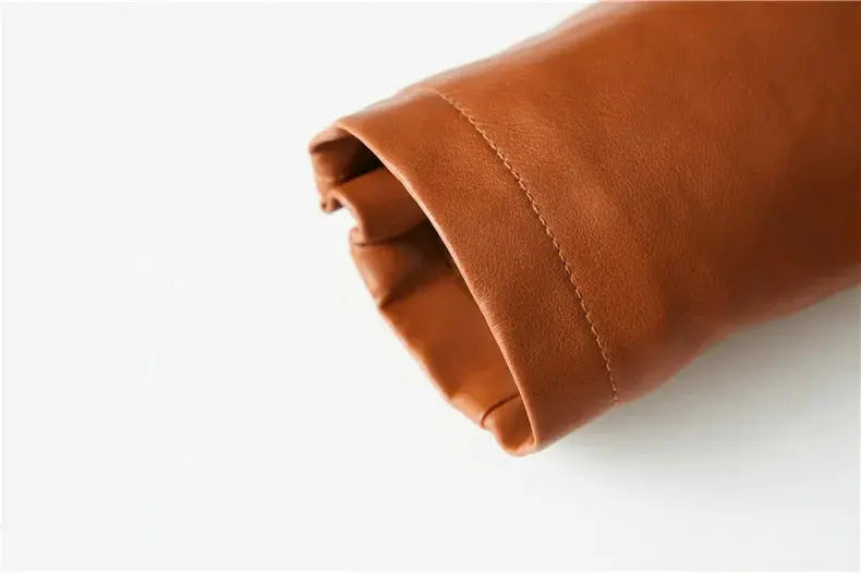 Leather jacket sleeve cuff in brown leather with stitched seam, close-up