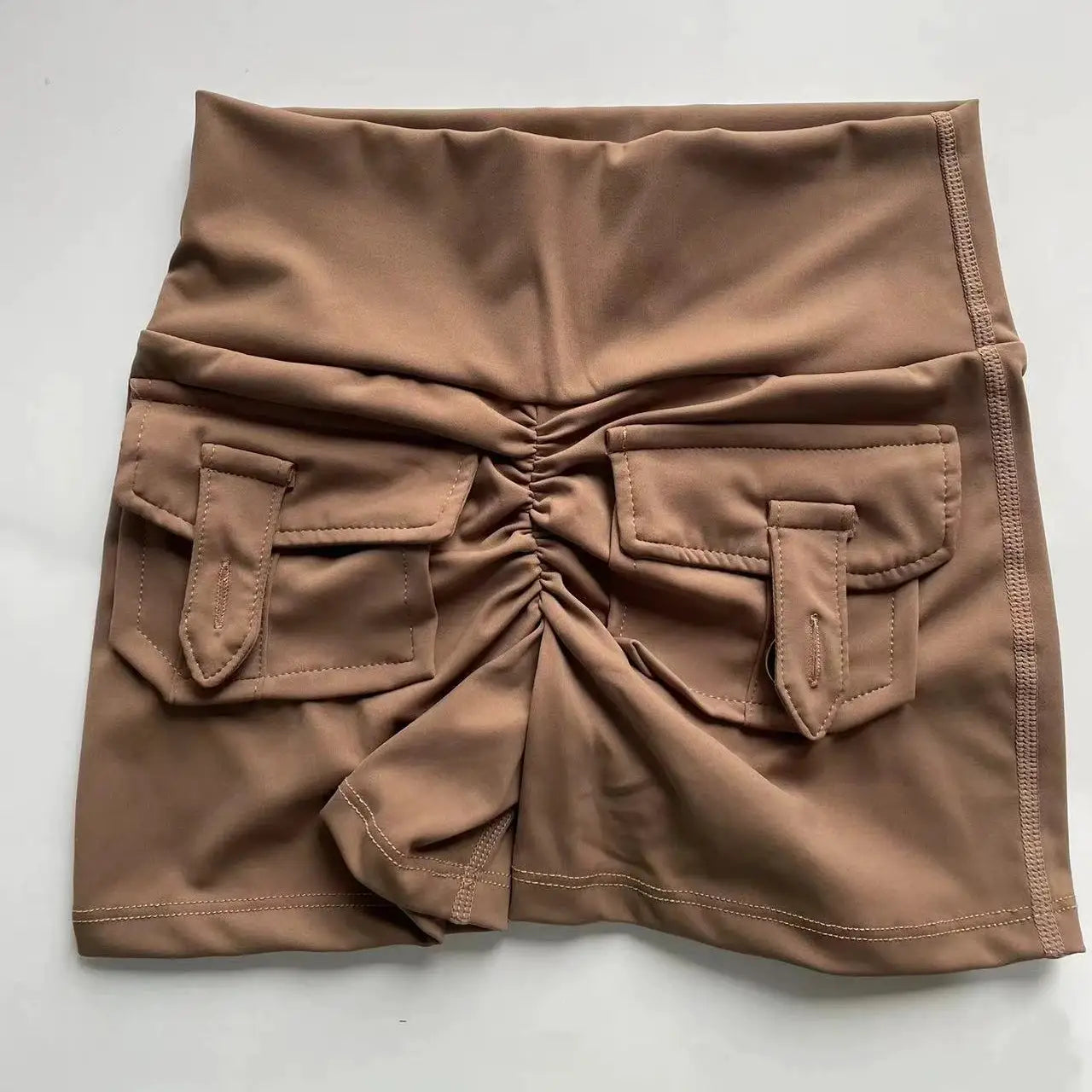 Peach women's fitness shorts with cargo pockets and ruched center seam, air-dry fabric
