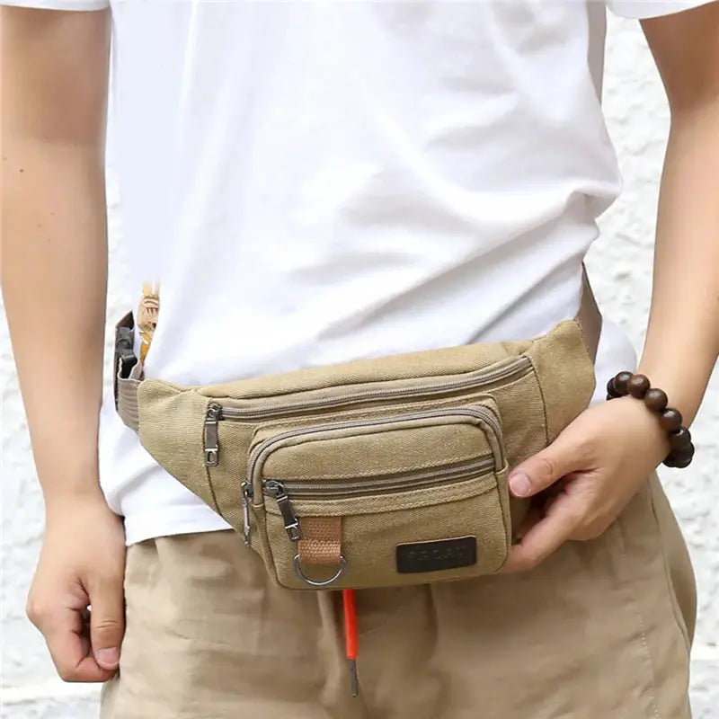 Simples Market canvas waist bag in tan with three zip pockets, worn at the hip.