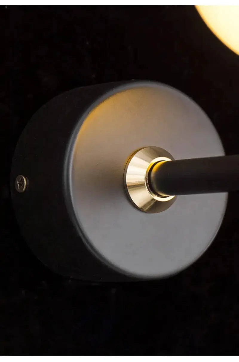 Modern LED wall lamp sconce with black circular backplate, brass ring around the mount and horizontal arm.