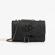 Women's luxury crossbody bag in black crocodile-embossed leather with silver chain strap and D-logo buckle.