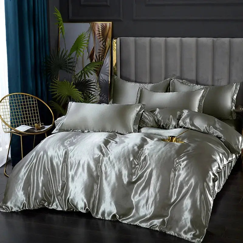 Silk satin bedding set in solid silver-gray on a bed with duvet, sheets and pillowcases.