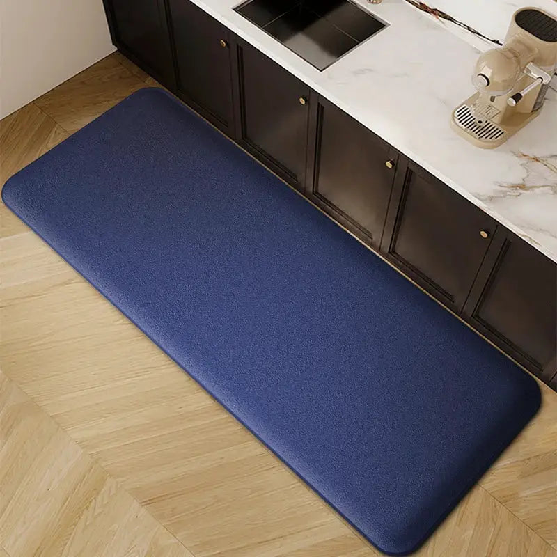 Blue long kitchen floor mat with thickened flannel texture, non-slip and absorbent, placed on wood floor beside cabinets