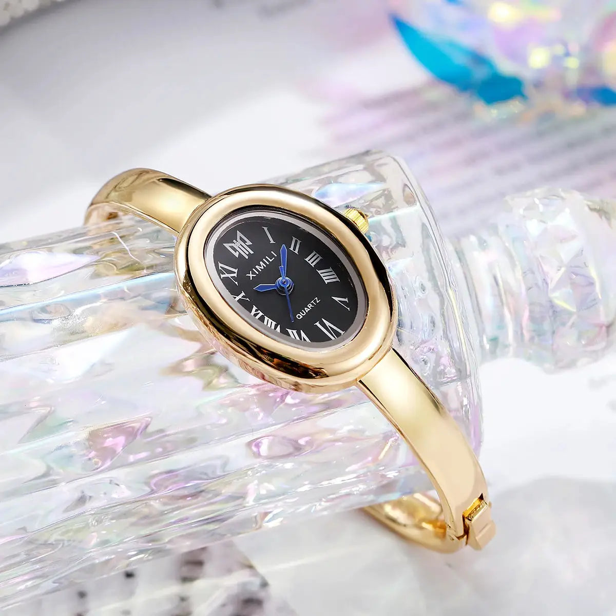 Gold-tone women's quartz wristwatch with black Roman numeral dial and blue hands