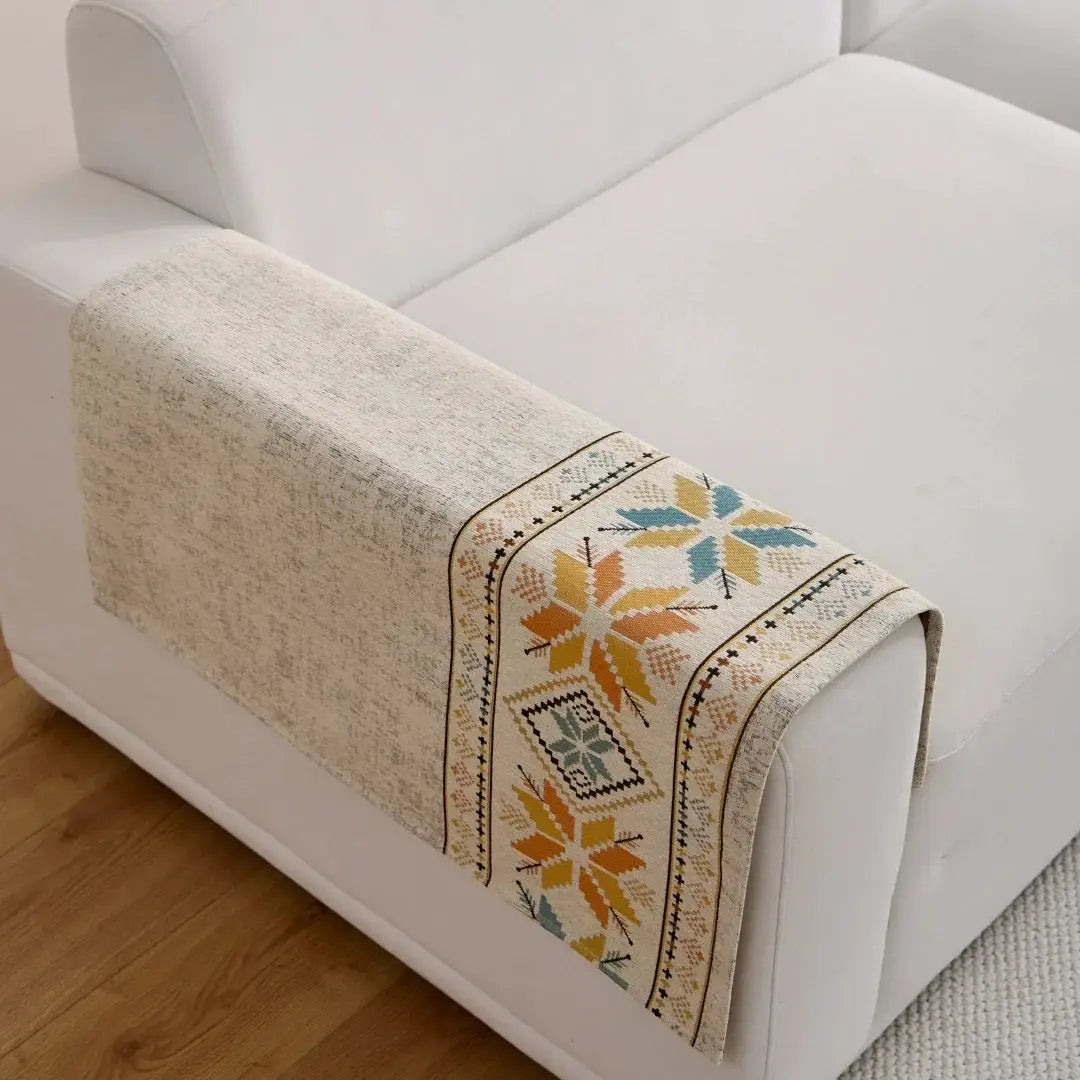 Bohemian Jacquard Chenille sofa throw by Simples Market on a cream couch with a multicolor geometric pattern