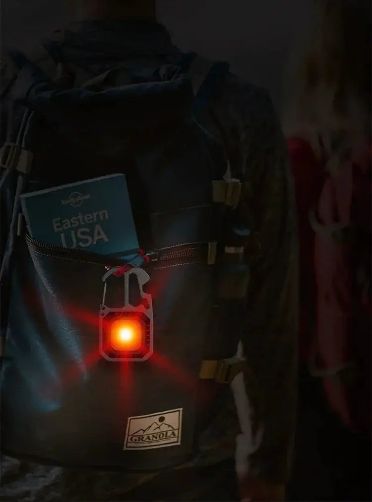 COB keychain work light with battery display attached to a hiking backpack; red LED glow, 8-mode rechargeable LED light