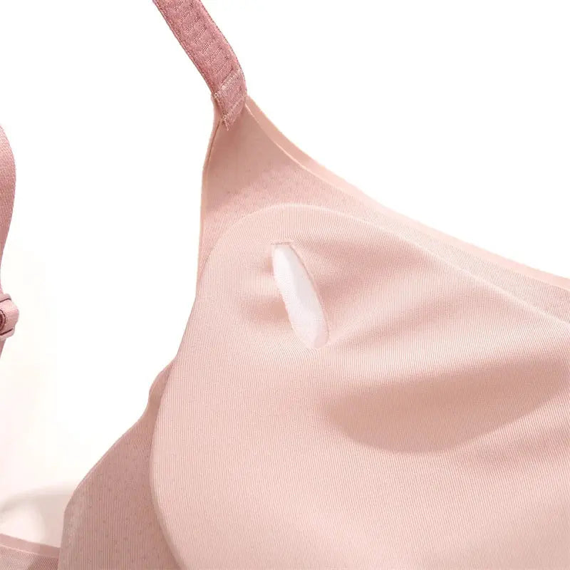 Women seamless bra with adjustable straps in pink, smooth fabric close-up