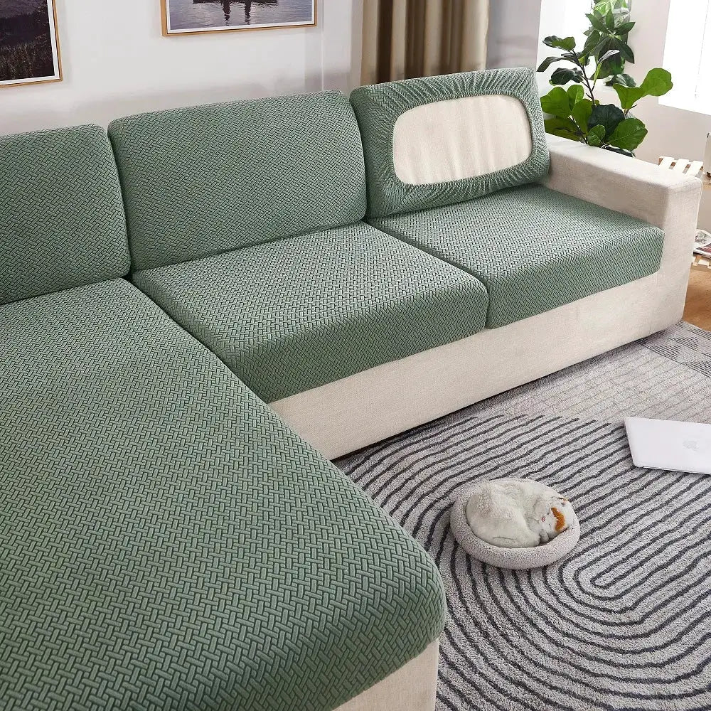 Thick jacquard sofa seat cushion covers in green on a beige sectional sofa; removable slipcovers.