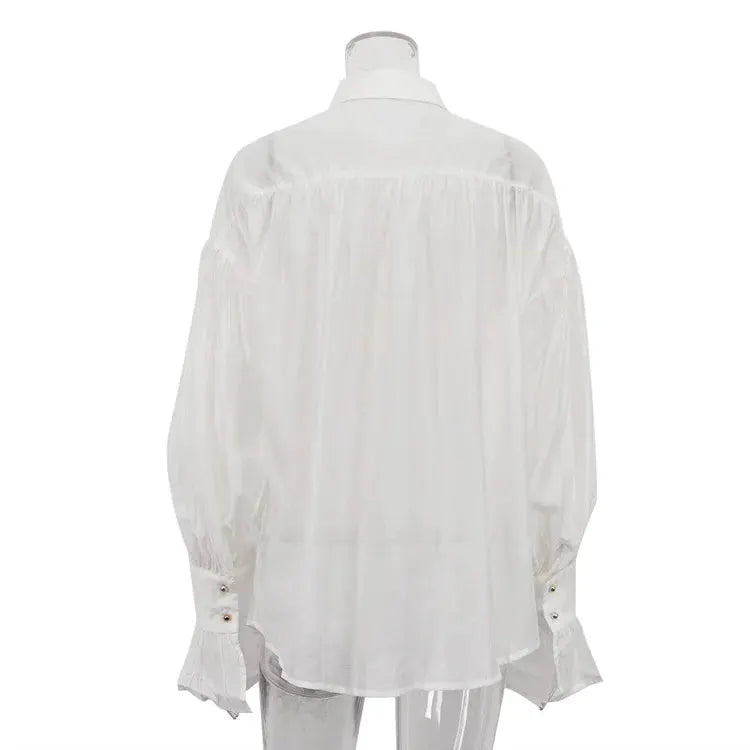 White loose collared shirt with flare sleeves and long buttoned cuffs